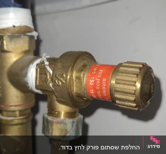 שסתום פליז עם תווית אדומה בצינור דוד שמש